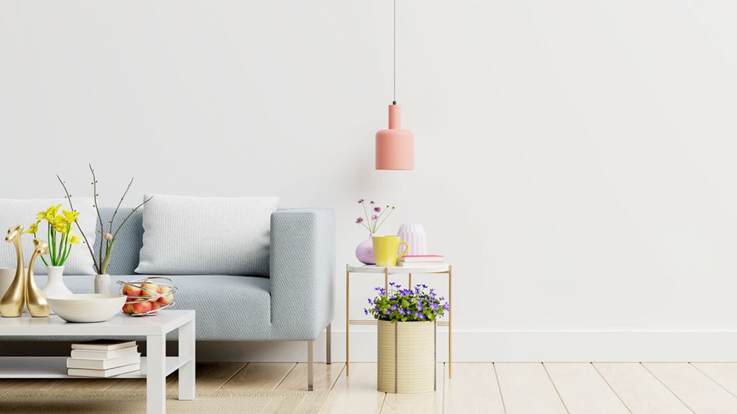 A fully-furnished living room with a light-blue sofa, pendant lamp and styled décor